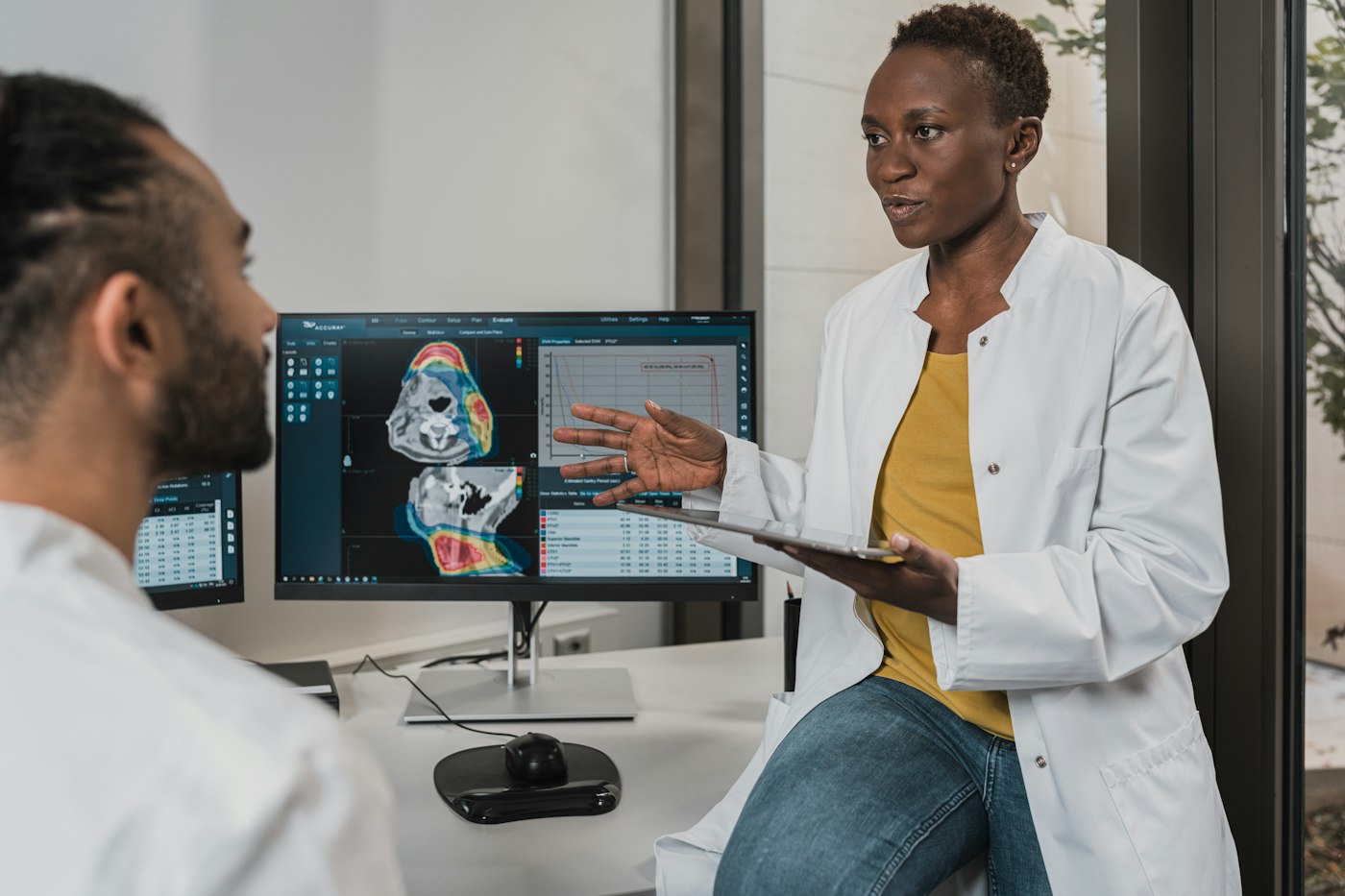Clinician speaking with a patient during a bedside consultation